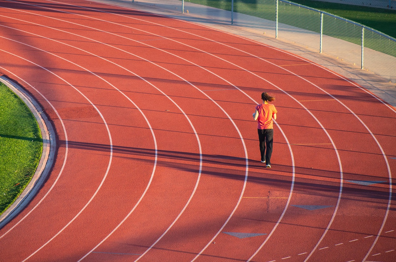 Person running around a running track from a distance